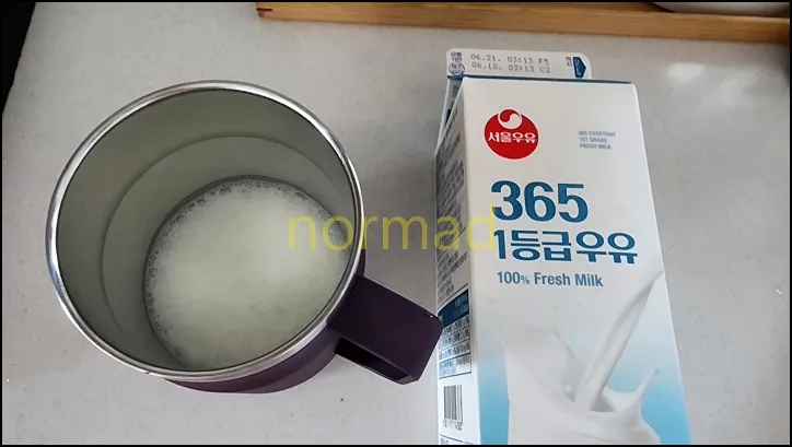 우유가 따라져 있는 컵과 900ml 우유